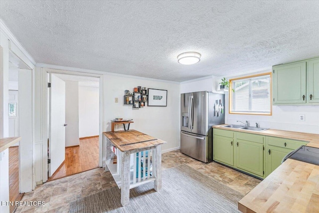 613 Victory St, Knoxville, TN 37919 - kitchen featuring green cabinets, stainless steel fridge with ice dispenser, butcher block countertops, a sink, and stone finish floors