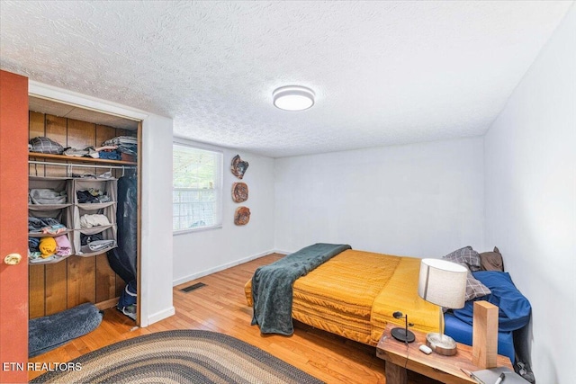 613 Victory St, Knoxville, TN 37919 - bedroom featuring wood finished floors, a textured ceiling, baseboards, and a closet