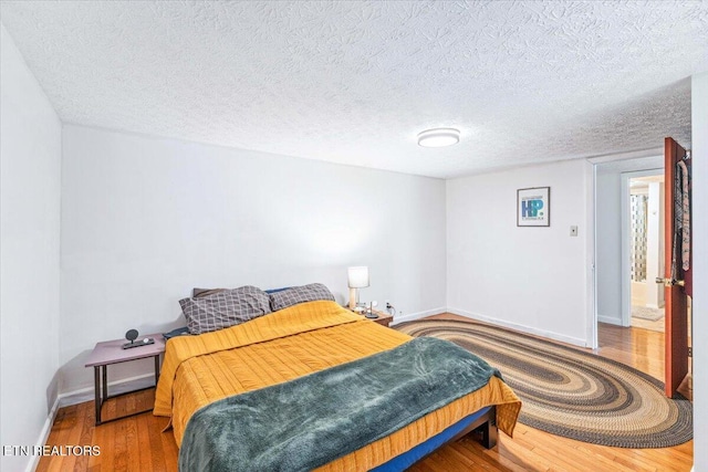613 Victory St, Knoxville, TN 37919 - bedroom with wood finished floors, baseboards, and a textured ceiling