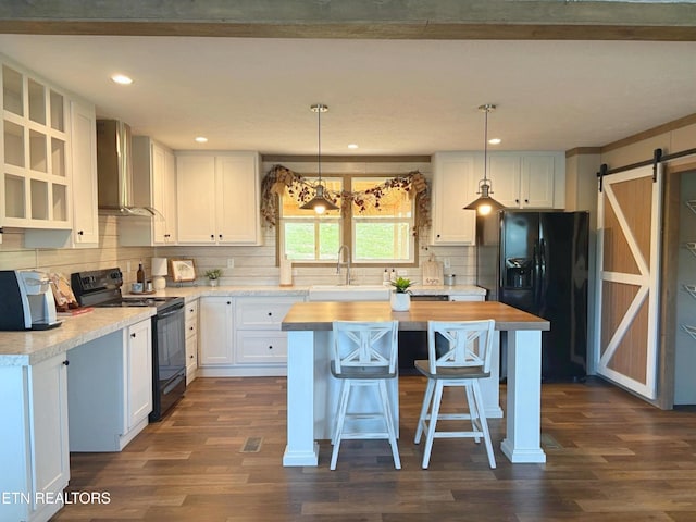 4501 Shipe Rd, Corryton, TN 37721 - kitchen featuring black appliances, wall chimney exhaust hood, a barn door, butcher block countertops, and a sink