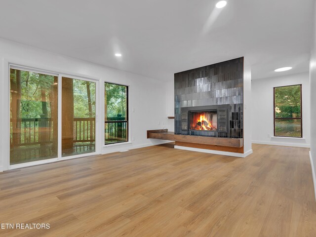 9501 E Aiken Ln, Knoxville, TN 37922 - unfurnished living room with a tile fireplace, plenty of natural light, light wood finished floors, recessed lighting, and baseboards