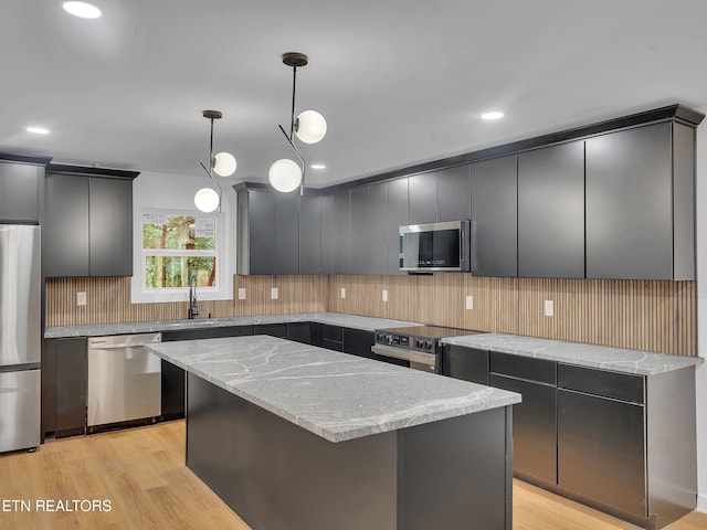 9501 E Aiken Ln, Knoxville, TN 37922 - kitchen with stainless steel appliances, a sink, tasteful backsplash, light wood finished floors, and pendant lighting
