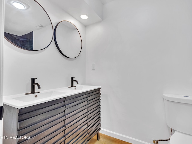 9501 E Aiken Ln, Knoxville, TN 37922 - bathroom with toilet, double vanity, wood finished floors, recessed lighting, and baseboards