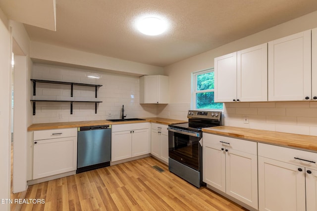 2800 Boyds Bridge Pike, Knoxville, TN 37914 - kitchen featuring butcher block countertops, dishwashing machine, stainless steel range with electric cooktop, a sink, and open shelves