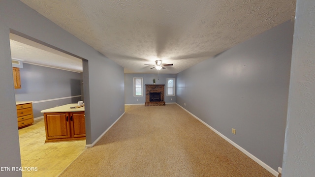 103 Mayfield Dr Unit 5, Elizabethton, TN 37643 - unfurnished living room featuring ceiling fan, a textured ceiling, baseboards, light colored carpet, and a fireplace