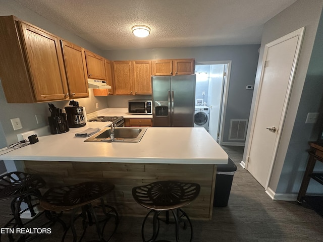 365 Moytoy Rd Unit 103, Crab Orchard, TN 37723 - kitchen featuring appliances with stainless steel finishes, washer / clothes dryer, under cabinet range hood, light countertops, and a peninsula