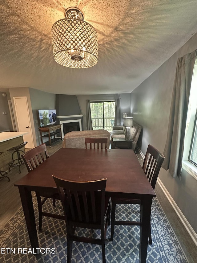 365 Moytoy Rd Unit 103, Crab Orchard, TN 37723 - dining room featuring wood finished floors, a textured ceiling, a chandelier, and a fireplace