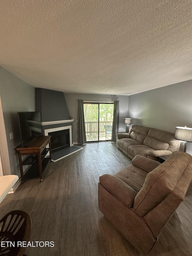 365 Moytoy Rd Unit 103, Crab Orchard, TN 37723 - living area with a fireplace with raised hearth, a textured ceiling, and dark wood finished floors