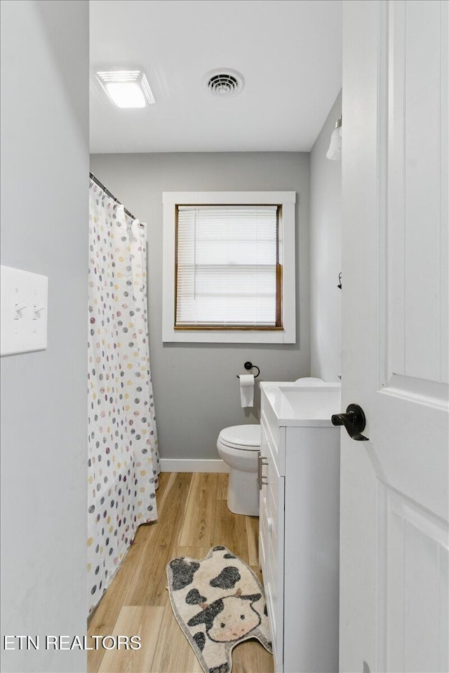 573 Patterson Rd, Harrogate, TN 37752 - full bath featuring vanity, wood finished floors, toilet, a shower with shower curtain, and baseboards
