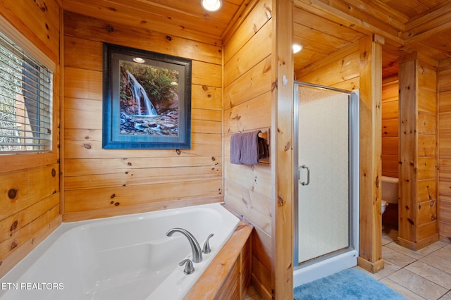 2456 Hackberry Dr, Sevierville, TN 37862 - bathroom featuring wood walls, a shower stall, a bath, tile patterned floors, and toilet