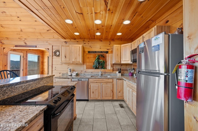 2456 Hackberry Dr, Sevierville, TN 37862 - kitchen featuring black appliances, recessed lighting, a sink, light brown cabinetry, and wood walls