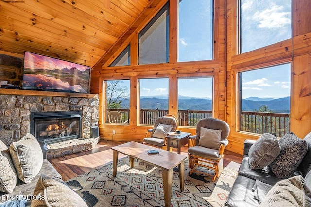 2456 Hackberry Dr, Sevierville, TN 37862 - living room featuring wood finished floors, a mountain view, a stone fireplace, healthy amount of natural light, and high vaulted ceiling