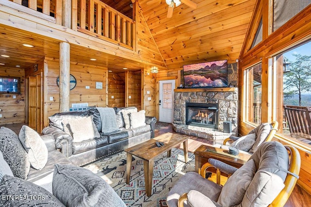 2456 Hackberry Dr, Sevierville, TN 37862 - living room with wooden walls, wood ceiling, a stone fireplace, wood finished floors, and high vaulted ceiling