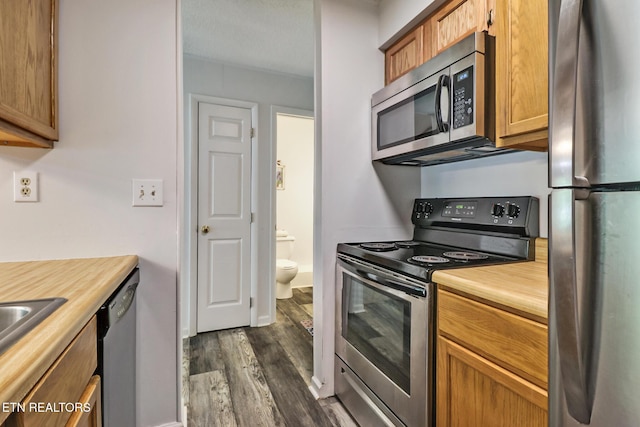 99 Wilshire Heights Dr Unit 99, Crossville, TN 38558 - kitchen with appliances with stainless steel finishes, dark wood-type flooring, and brown cabinets