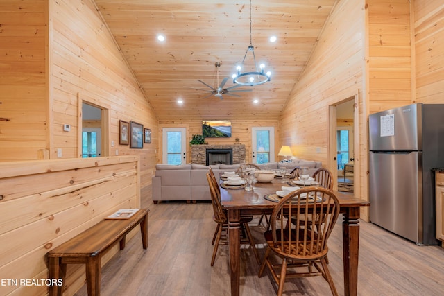 1646 Misty Hollow Way, Gatlinburg, TN 37738 - dining space with wooden walls, light wood-style floors, wooden ceiling, ceiling fan, and a stone fireplace
