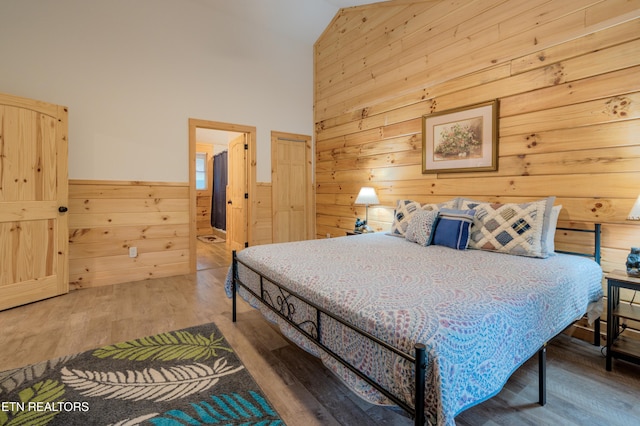 1646 Misty Hollow Way, Gatlinburg, TN 37738 - bedroom with wood walls, wood finished floors, high vaulted ceiling, and a wainscoted wall