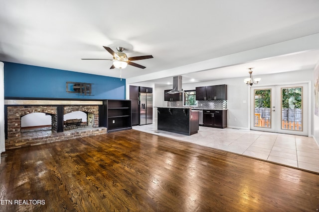 9005 Carlton Cir, Knoxville, TN 37922 - unfurnished living room featuring a chandelier, light wood-type flooring, ceiling fan, a fireplace, and baseboards