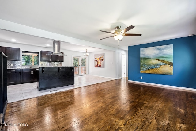 9005 Carlton Cir, Knoxville, TN 37922 - unfurnished living room featuring a ceiling fan, a chandelier, light wood-type flooring, and baseboards