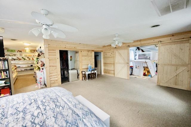 2645 Mountain View Dr, Morristown, TN 37814 - carpeted bedroom featuring wood walls, a barn door, and ceiling fan