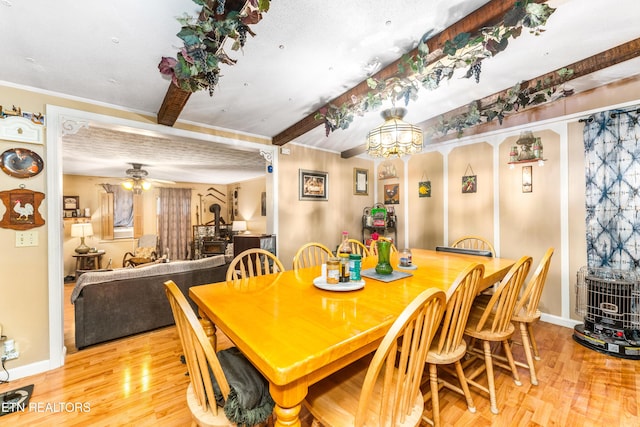 1069 Bryan View Rd, Sevierville, TN 37862 - dining space with a wood stove, wood finished floors, baseboards, beamed ceiling, and ceiling fan