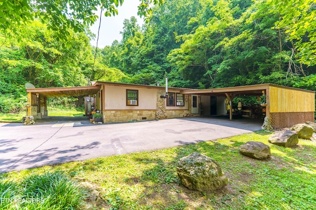 1069 Bryan View Rd, Sevierville, TN 37862 - view of front facade with stone siding, driveway, a forest view, and a carport