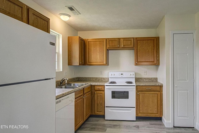 1505 Cypress View Ct, Sevierville, TN 37862 - kitchen with white appliances, a sink, light wood finished floors, and brown cabinetry