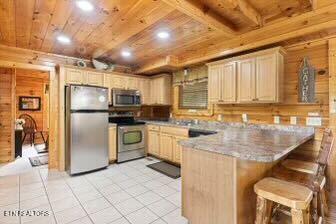 1665 Mountain Lodge Way, Pigeon Forge, TN 37862 - kitchen featuring stainless steel appliances, a peninsula, wooden ceiling, light tile patterned floors, and a breakfast bar