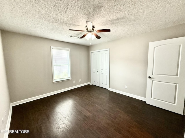 304 Douglas Ave, Knoxville, TN 37921 - unfurnished bedroom featuring baseboards, dark wood-style floors, a closet, a textured ceiling, and ceiling fan