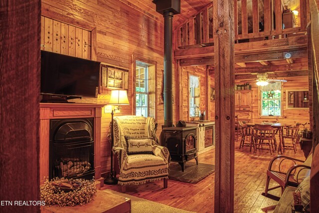 147 Akers Chapel, Jamestown, TN 38556 - sitting room featuring a wood stove, wood walls, a high ceiling, wood-type flooring, and plenty of natural light