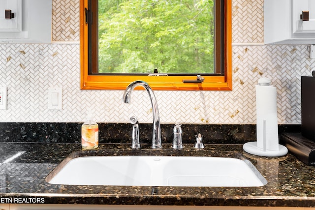 1139 Reagan Valley Rd, Tellico Plains, TN 37385 - detailed view of decorative backsplash, dark stone countertops, and white cabinetry