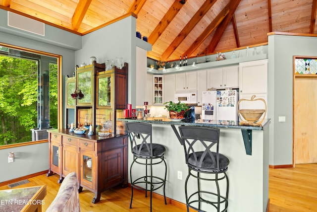 1139 Reagan Valley Rd, Tellico Plains, TN 37385 - kitchen featuring a wood ceiling with exposed beams, white appliances, white cabinetry, a breakfast bar, and light wood-type flooring