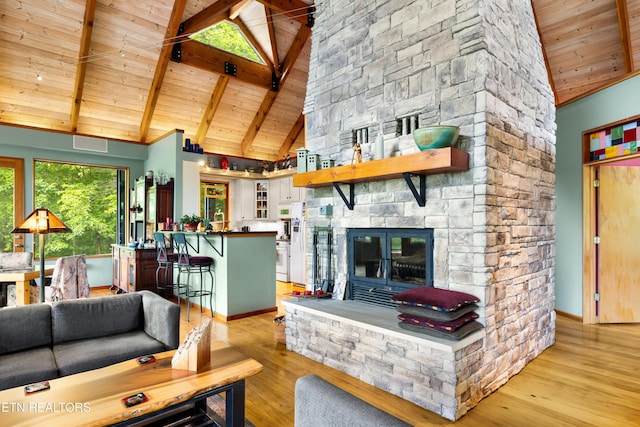 1139 Reagan Valley Rd, Tellico Plains, TN 37385 - living room featuring light wood finished floors, a wooden ceiling with exposed beams, high vaulted ceiling, and a stone fireplace