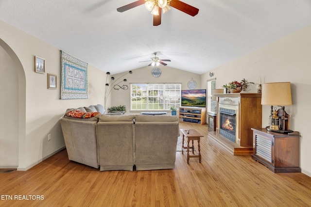 1647 Sams Dr, Dandridge, TN 37725 - living room featuring ceiling fan, arched walkways, a fireplace, light wood-style floors, and vaulted ceiling