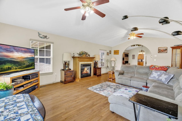 1647 Sams Dr, Dandridge, TN 37725 - living area featuring ceiling fan, lofted ceiling, arched walkways, light wood-type flooring, and a glass covered fireplace
