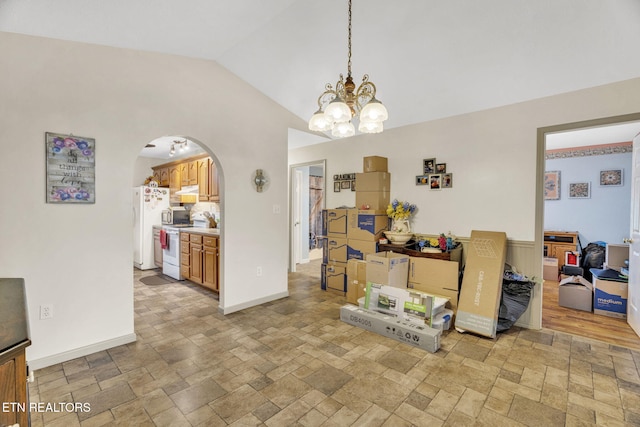 1647 Sams Dr, Dandridge, TN 37725 - dining area featuring light stone finish flooring, arched walkways, vaulted ceiling, a chandelier, and baseboards