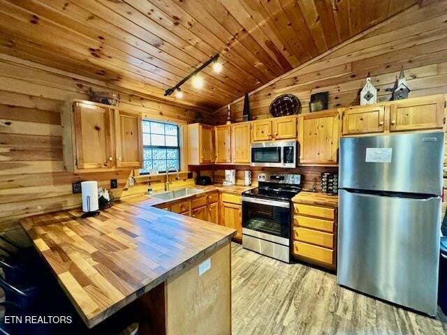 1930 Regans Ridge Way, Sevierville, TN 37876 - kitchen with stainless steel appliances, a sink, rail lighting, lofted ceiling, and wooden ceiling