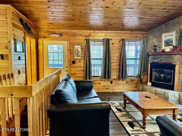 1930 Regans Ridge Way, Sevierville, TN 37876 - living room featuring wooden ceiling, plenty of natural light, wooden walls, a stone fireplace, and wood finished floors