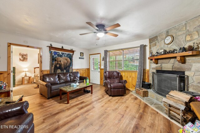 1737 Walker Trl, Sevierville, TN 37876 - living room with a wainscoted wall, a ceiling fan, wood finished floors, a stone fireplace, and wood walls