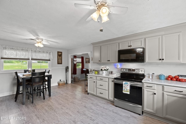 8318 Clapps Chapel Rd, Corryton, TN 37721 - kitchen with black microwave, stainless steel electric range, ceiling fan, light countertops, and a textured ceiling