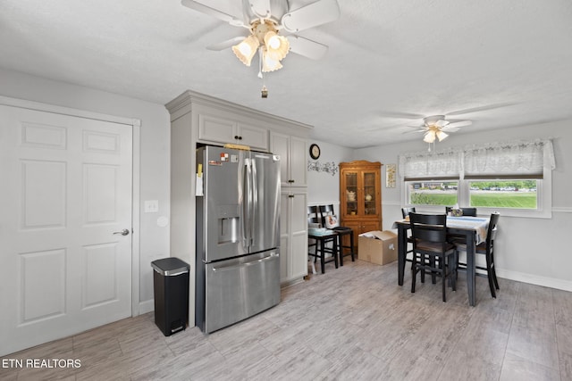 8318 Clapps Chapel Rd, Corryton, TN 37721 - kitchen featuring stainless steel fridge with ice dispenser, ceiling fan, light wood-type flooring, baseboards, and a textured ceiling