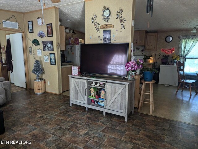 626 S 22nd St, Middlesboro, KY 40965 - living room featuring a textured ceiling, stone finish floors, and vaulted ceiling