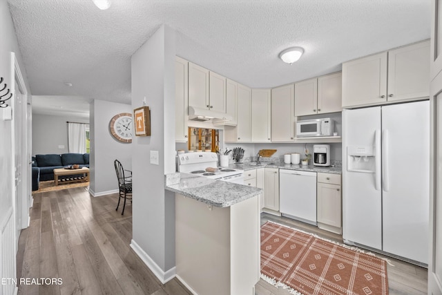 613 Vose Rd Unit B, Alcoa, TN 37701 - kitchen with white appliances, a textured ceiling, light wood-style flooring, light stone counters, and baseboards