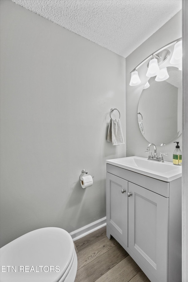 613 Vose Rd Unit B, Alcoa, TN 37701 - half bathroom with a textured ceiling, vanity, wood finished floors, baseboards, and toilet