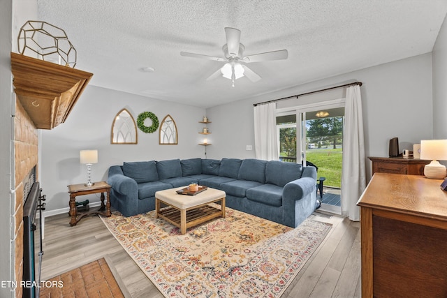 613 Vose Rd Unit B, Alcoa, TN 37701 - living area featuring a ceiling fan, a fireplace, light wood-style flooring, and a textured ceiling
