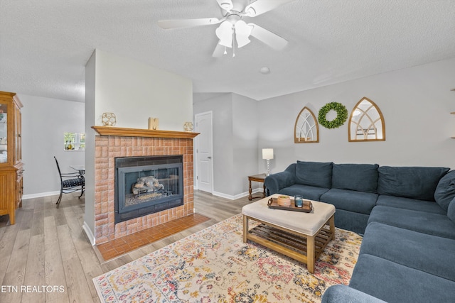 613 Vose Rd Unit B, Alcoa, TN 37701 - living area featuring a textured ceiling, wood finished floors, a ceiling fan, a fireplace, and baseboards