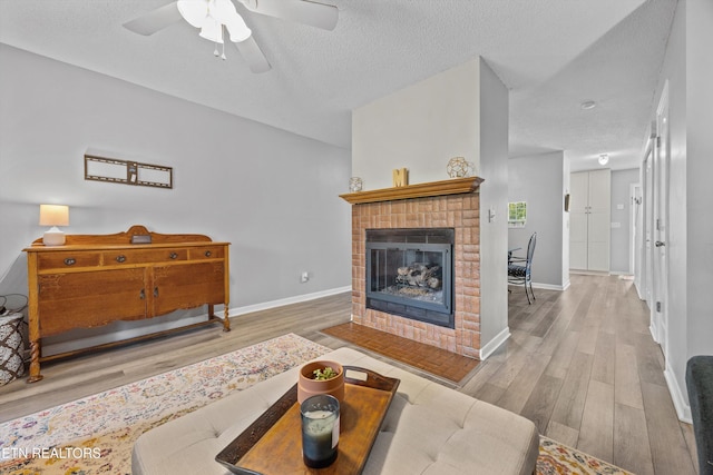 613 Vose Rd Unit B, Alcoa, TN 37701 - living room with wood finished floors, ceiling fan, a fireplace, a textured ceiling, and baseboards
