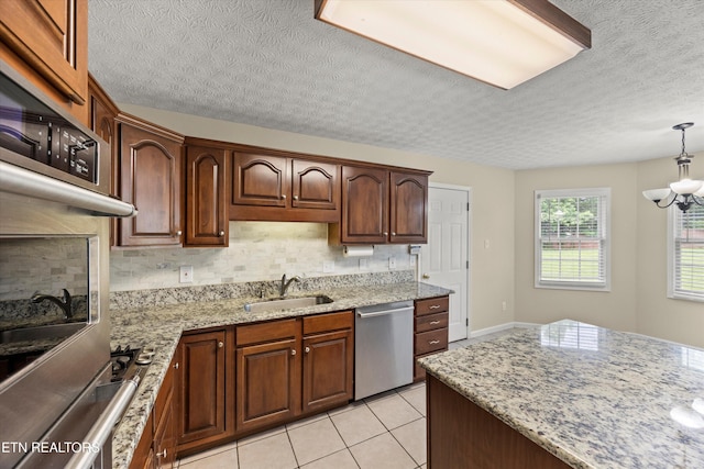 7127 Fieldstone Farms Ln, Knoxville, TN 37921 - kitchen with stainless steel appliances, a sink, a textured ceiling, decorative backsplash, and light stone counters