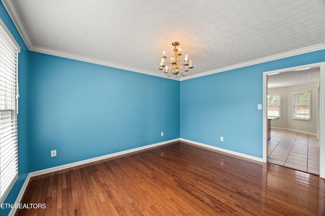 7127 Fieldstone Farms Ln, Knoxville, TN 37921 - empty room with a chandelier, baseboards, wood finished floors, crown molding, and a textured ceiling