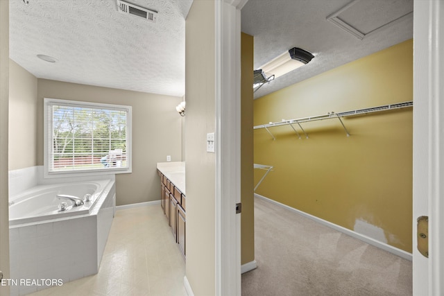 7127 Fieldstone Farms Ln, Knoxville, TN 37921 - bathroom with a bath, vanity, a textured ceiling, baseboards, and a walk in closet
