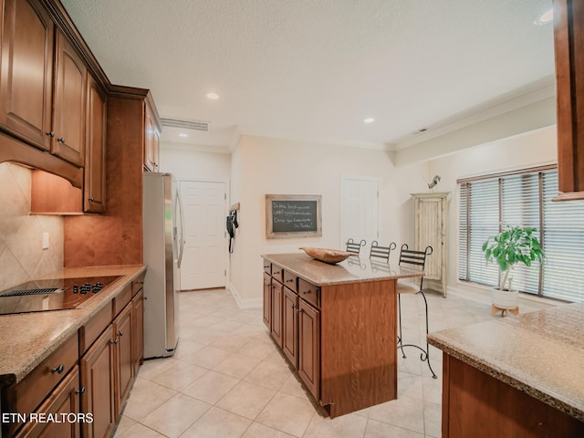 1201 Bentley Park Ln, Knoxville, TN 37922 - kitchen with freestanding refrigerator, a kitchen breakfast bar, black electric cooktop, a kitchen island, and decorative backsplash
